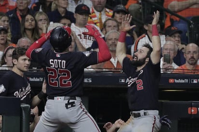 Juan Soto celebra con Adam Eaton tras conectar un cuadrangular, con el que Nacionales le dio la vuelta a la pizarra. (AP)