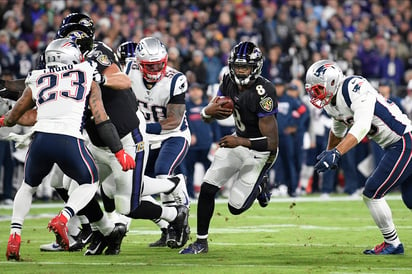 El mariscal de los Cuervos, Lamar Jackson (8), anotó vía terrestre en par de ocasiones. (AP)