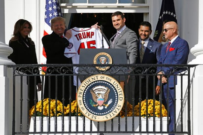 El primera base de los Nacionales de Washington, Ryan Zimmerman (c) entrega una camiseta al presidente de Estados Unidos, Donald Trump ayer durante el evento para celebrar la victoria del equipo en la Serie Mundial. (AP)