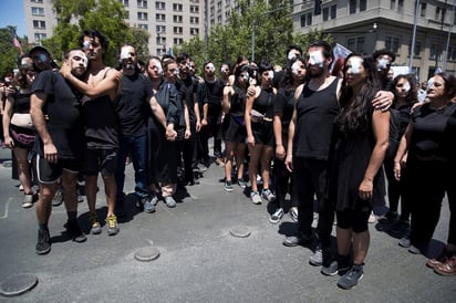 Manifestantes representan a quienes han recibido disparos en sus ojos por parte de las fuerzas policiales en jornadas de protestas en Santiago. (EFE)