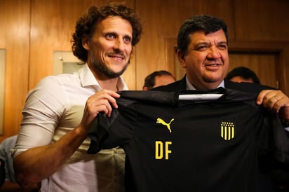 El exfutbolista recibe la playera por parte del presidente del club, Jorge Barrera (d).