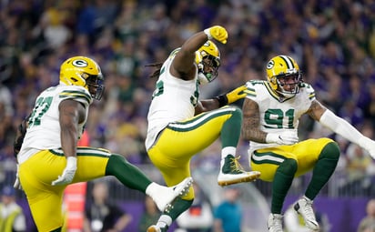 Kenny Clark (i), Za'Darius Smith y Preston Smith (d), celebran tras una captura a Kirk Cousins, durante el primer medio del juego de ayer, que Green Bay ganó 23-10 a Minnesota. (AP)