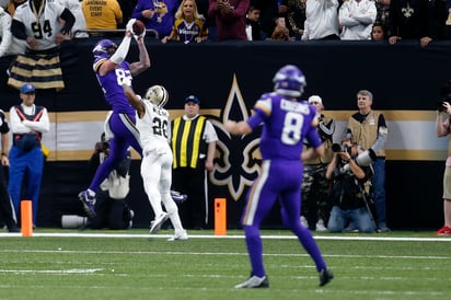 Kyle Rudolph (i) se eleva para atrapar el pase de anotación que le dio la victoria a los Vikingos en tiempo extra ante los Santos. (AP)