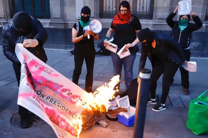 Una docena de mujeres protestaron afuera de Palacio Nacional por el feminicidio de Ingrid Escamilla, así como por el clima de violencia y por el alto índice de feminicidios que hay en país, donde quemaron la reproducción de un boleto de la rifa del avión presidencial. (EL UNIVERSAL)