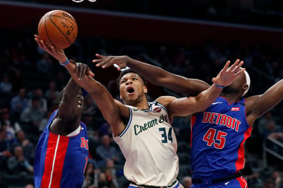 El alero de los Bucks de Milwaukee Giannis Antetokounmpo (34) dispara ante la defensiva de los aleros de los Pistons de Detroit. (AP)