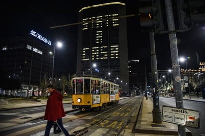 Un edificio en Milán, Italia llama a la ciudadanía a estar en casa, mientras se observa un transeúnte. (EFE) 