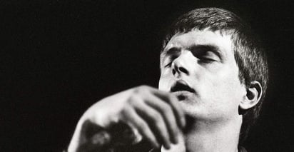 Un día antes de marcharse de gira a Estados Unidos, Ian Curtis se suicidó. Se ahorcó en la cocina de su casa. Se colgó de un tendedero mientras en su tocadiscos sonaba Iggy Pop. Puso fin a Joy Division y creó un mito romántico en torno a él. Murió la persona, nació la leyenda. (ESPECIAL)
