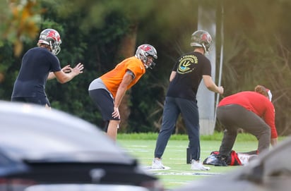 Tom Brady (jersey naranja) entrenó ayer con algunos compañeros en un campo de una escuela secundaria. (AP)