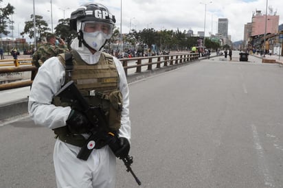 Militares vestidos con trajes de bioseguridad requerían a los transeúntes los documentos para verificar si tenían permitido salir. (EFE) 