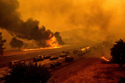 La ceniza esparcida en el suelo y el humo no favorecen al estado frente a la pandemia. (AP) 