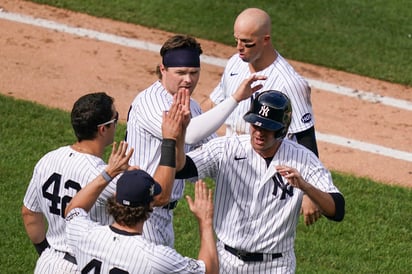 Jugadores de los Yanquis celebran tras anotar la carrera del triunfo.