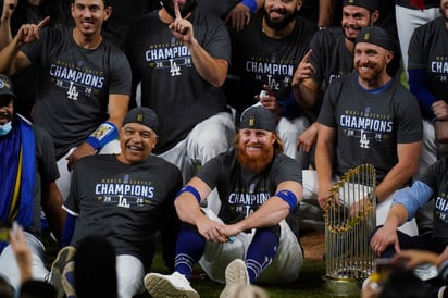 Justin Turner (c), quien tuvo que dejar el juego del martes tras recibir la noticia que dio positivo a COVID-19, regresó al terreno de juego para festejar el título, e incluso se quitó el cubrebocas. (AP)