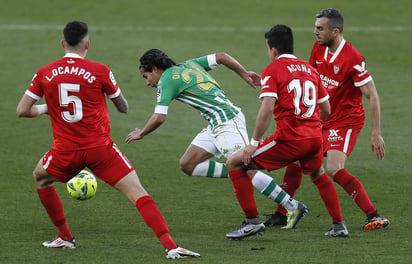 El mexicano Diego Lainez, escapa de la marca de los jugadores del Sevilla, Acuña y Ocampos, durante el derbi andaluz en el Benito Villamarín.