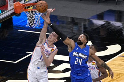 Aleksej Pokusevski (izq) de Oklahoma y el centro Khem Birch del Magic, disputan la pelota en un cerrado encuentro jugado en Florida. (Especial)