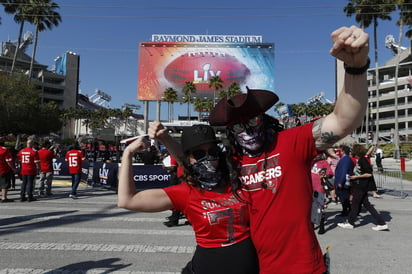 Portando máscaras N95 y protectores faciales, John Goodman, su esposa Alison McMillan y sus dos hijos adolescentes se abrieron paso entre las aglomeraciones en las calles aledañas al estadio Raymond James y se instalaron en sus asientos para el Super Bowl casi tres horas antes de que iniciara. (EFE)
