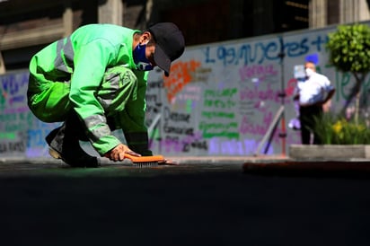 Tres camiones de limpieza y cerca de 30 trabajadores estuvieron limpiando este lunes los centenares de mensajes pintados. EFE)