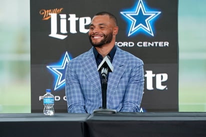 El mariscal de campo de los Vaqueros de Dallas, Dak Prescott, sonríe durante la conferencia de prensa en las instalaciones del equipo para anunciar oficialmente el contrato más caro en la historia del franquicia. (AP)