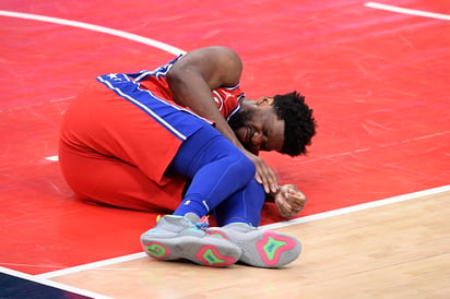 Joel Embiid se queja tras sufrir una lesión en la rodilla izquierda en el juego de ayer ante Wizards. (AP)