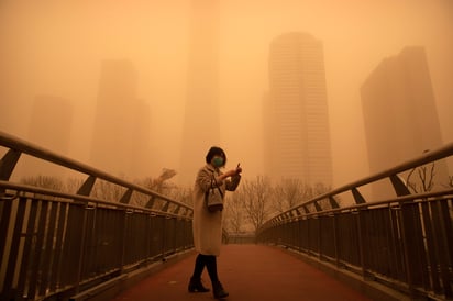 Los rascacielos del centro de Beijing parecían haber desaparecido de la vista entre el polvo y la arena. (AP) 