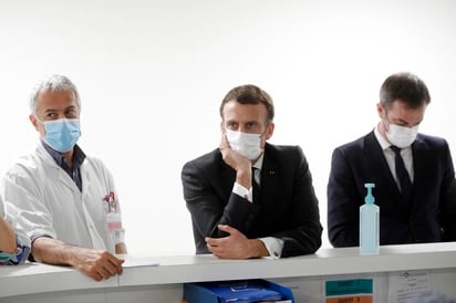 El presidente francés Emmanuel Macron, al centro; el ministro de Salud Olivier Veran, derecha; y el jefe de la unidad de cuidados intensivos del hospital Poissy/Saint-Germain-en-Laye, doctor Jan Hayon, escuchan el miércoles 17 de marzo del 2021 al personal que trabaja en cuidados intensivos en ese hospital, cerca de París. (Yoan Valat, Pool vía AP)