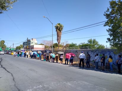 Había ciudadanos y ciudadanas con sombrillas, gorras, bancos y sillas mientras esperaban su turno. (EL SIGLO DE TORREÓN)