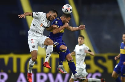 Junior Alonso del Atlético Mineiro de Brasil, a la izquierda, y Marcelo Weigandt de Boca Juniors de Argentina intentan cabecear un balón durante el partido de ida por los octavos de final de la Copa Libertadores, en Buenos Aires, Argentina, el martes 13 de julio de 2021. (Marcelo Endelli/ Pool vía AP)