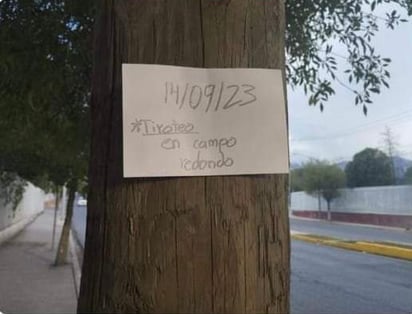 El cartel fue colocado en uno de los postes de madera en la entrada del campus. (REDES SOCIALES)