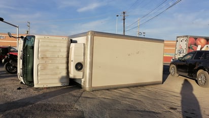 Camión de reparto de productos lácteos termina volcado tras chocar con una camioneta.