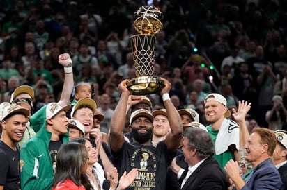 Jaylen Brown sostiene el Trofeo del Campeonato Larry O'Brien mientras celebra con el equipo después de que ganaron el campeonato de la NBA. (AP)