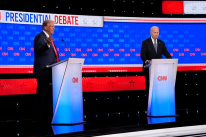 El presidente Joe Biden (derecha) escucha mientras el candidato republicano a la presidencia, el expresidente Donald Trump habla durante el debate presidencial realizado por la cadena CNN. (AP)