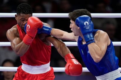 El boxeador mexicano Marco Verde conecta un golpe al mozambiqueño Tiago Muxanga, dentro de la ronda de octavos de final de los Juegos Olímpicos de París 2024. (AP)
