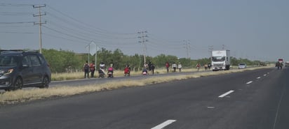 A pie. Con una temperatura en ese momento de 32 °C, caminaban a orilla de la carretera; cabe mencionar que ciudadanos acudieron en vehículos para proporcionales alimento y bebidas.