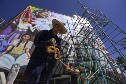 La artista mexicana Janet Calderón se prepara para trabajar en un mural que está ayudando a pintar en San Salvador, Hidalgo (AP) 