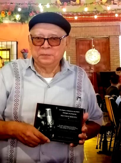 Alejandro Rodríguez al momento de recibir
su reconocimiento de manos de su
compañero Manlio Favio Godoy