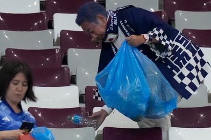 Sacaron de sus mochilas bolsas de plástico, de color azul, y depositaron en ellas cualquier desperfecto abandonado en los asientos, caído en el suelo. (AP)