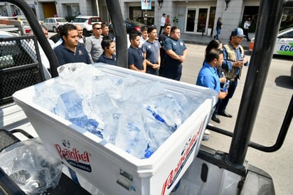 Elementos municipales de policía y de Protección Civil de Monclova, avituallados con barras de hielo y botellines en hieleras en la caja de una patrulla, recorrieron las calles de la ciudad de Monclova.