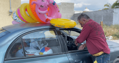 Jaime tiene 62 años y acompañado de su automóvil, un palo de madera y unas ganas enormes de no quedarse atrás, recorre cada fin de semana las quintas de Torreón, vendiendo globos y salvavidas. (ÁNGEL F. CHÁVEZ FÉLIX)