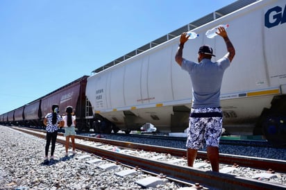 Laguneros esperan a los viajeros para entregarles provisiones que les puedan ayudar en su camino hacia la frontera. (VAYRON INFANTE / EL SIGLO DE TORREÓN)