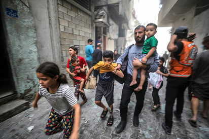 Una familia palestina corre para ponerse a salvo durante un bombardeo israelí sobre Gaza, el 23 de octubre. Imagen: EFE / Mohammed Saber