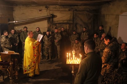 Ivan, capellán de la Iglesia ortodoxa de Ucrania, lee una oración por un soldado de la 72da brigada mecanizada del ejército ucraniano durante una misa, en el frente, cerca de Vuhledar, Ucrania. (Valentyn Kuzan / AP)