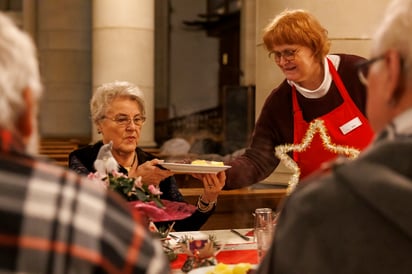 Personas pobres y sin hogar recibieron una comida navideña tradicional durante el evento.  (CHRISTOPHER NEUNDORF / EFE)