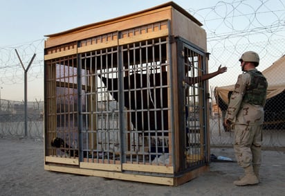 Un detenido en confinamiento solitario habla con un oficial de la policía militar en la prisión de Abu Ghraib. (AP)
