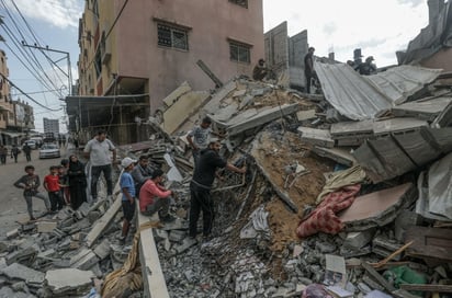 Palestinos buscan a personas desaparecidas entre los escombros tras un ataque israelí en el campo de refugiados de Al Nuseirat. (EFE)