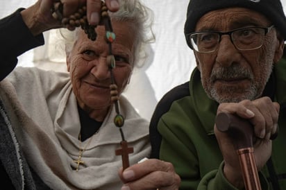 Tony (derecha), de 78 años, y su esposa Amal (izquierda), ambos palestinos cristianos desplazados internamente, se sientan dentro de su tienda de campaña en la zona de Al-Mawasi, Khan Younis, en el sur de la Franja de Gaza, el 25 de diciembre de 2024. La pareja cristiana palestina reside actualmente en una tienda de campaña tras su desplazamiento desde el norte de Gaza, donde no han podido viajar a Belén para celebrar la Navidad por segundo año consecutivo debido al cierre de fronteras y las continuas hostilidades.