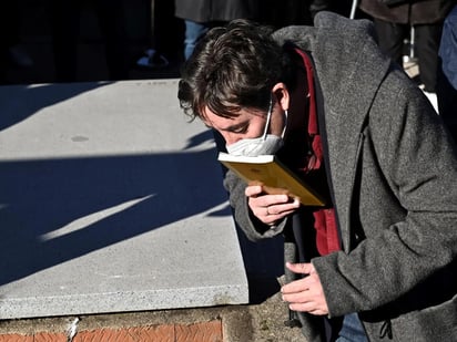 Luis García Montero besa el poemario Completamente viernes, antes de sepultarlo junto a su esposa, la escritora Almudena Grandes. Imagen EFE