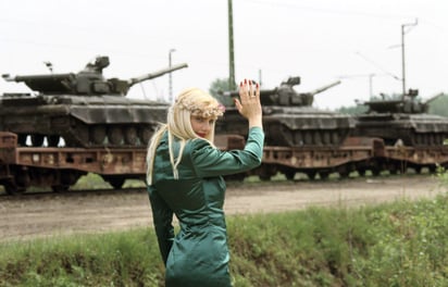 magen: GettyImages. Cicciolina diciendo adiós a los tanques soviéticos mientras se retiran de su natal Hungría, 1990.  