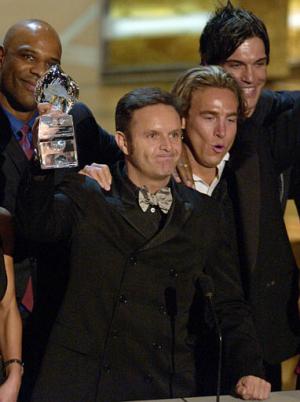 El productor  Mark Burnett sostiene su premio por el mejor “reality show” con los integrantes del elenco de 'Survivor: Thailand' , a su izquierda esta Ted Rogers, Jr. y a su derecha están Jed Hildebrand y Robb Zbacnik.