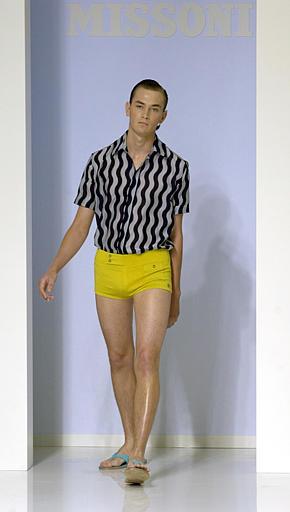Dentro de la colección de Missoni para el 2004, este modelo porta un traje de baño amarillo combinado con una camisa con rayas negras y grises.