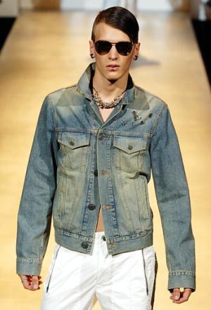 Este modelo usa una chaqueta de mezclilla y pantalones blancos durante el desfile de John Richmond en Milán.