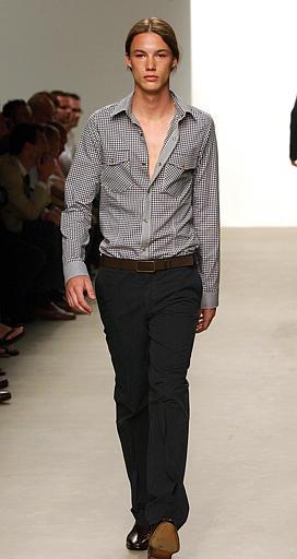 Un diseño un poco más vanguardista de pantalón negro  y camisa gris, es presentado por este modelo dentro de la colección primavera-verano 2004 de Cavin Klein.